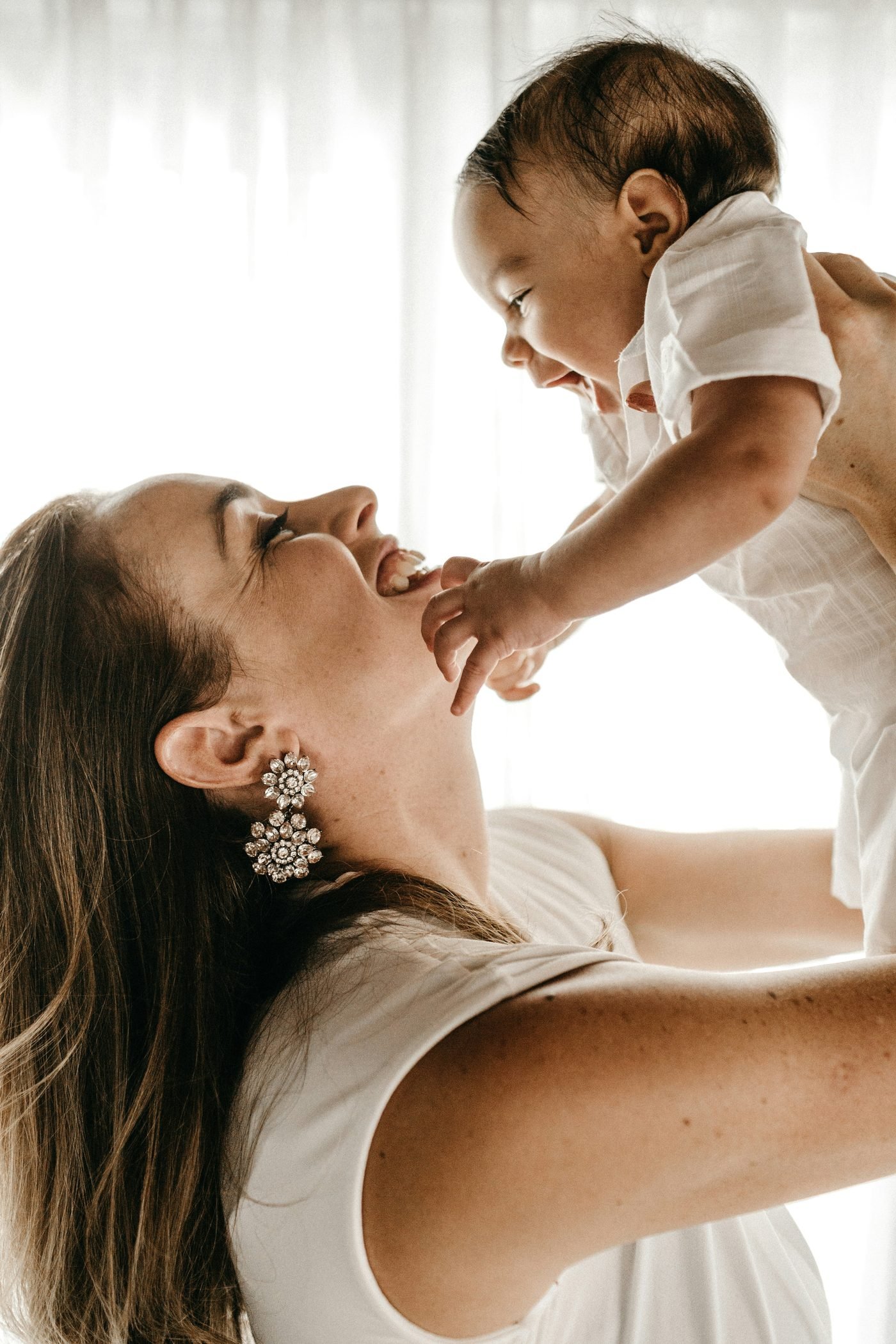 Mutter hält lachend ihr Baby in die Höhe